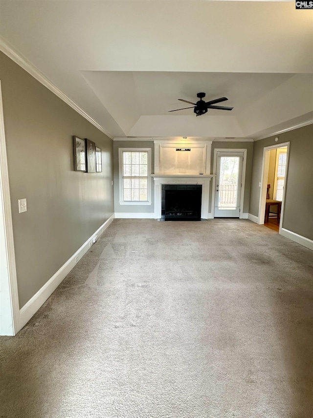 unfurnished living room featuring crown molding, a raised ceiling, a fireplace, and baseboards