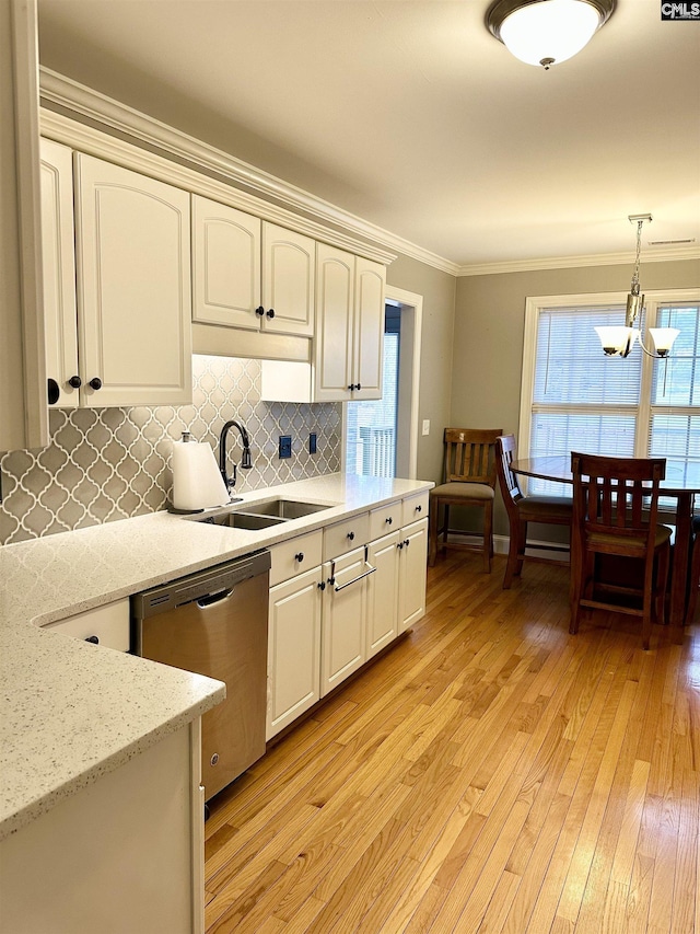 kitchen featuring backsplash, stainless steel dishwasher, crown molding, light wood-style floors, and a sink