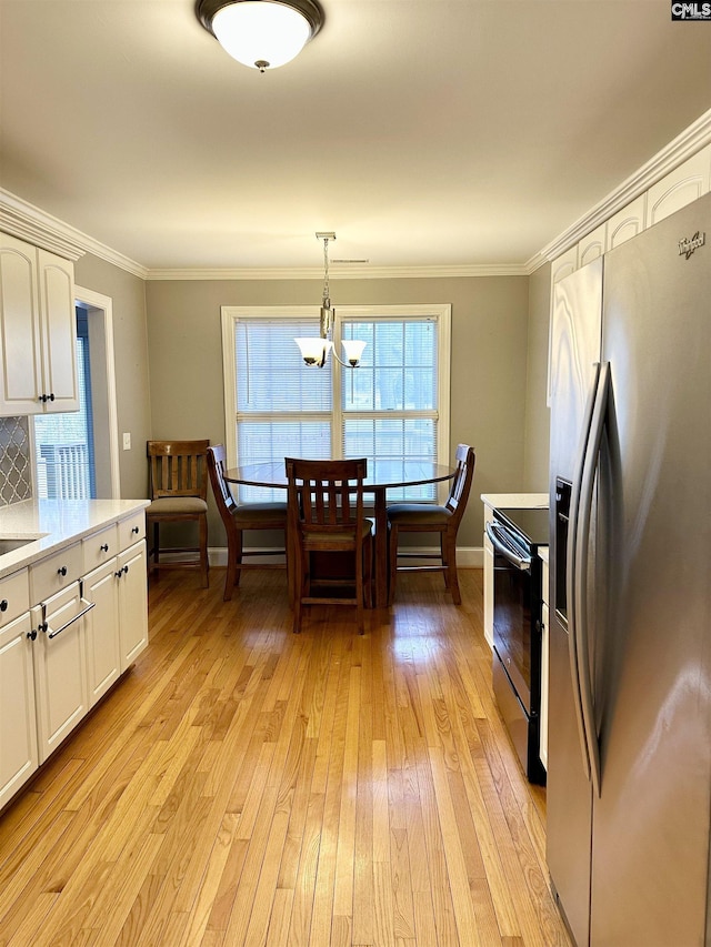 kitchen with electric range, light wood-style floors, light countertops, stainless steel fridge with ice dispenser, and crown molding