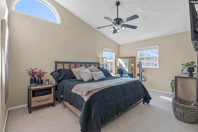 bedroom featuring light colored carpet, ceiling fan, a textured ceiling, high vaulted ceiling, and baseboards