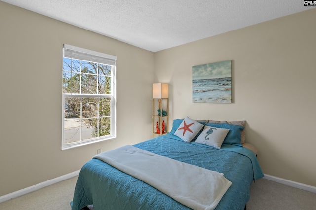 carpeted bedroom with a textured ceiling and baseboards