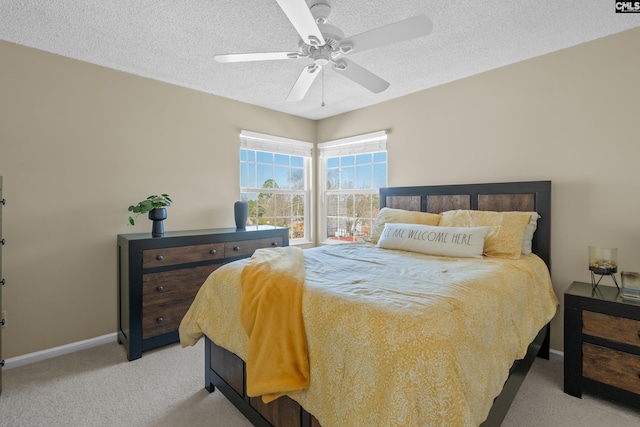 bedroom with a textured ceiling, ceiling fan, carpet flooring, and baseboards