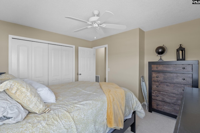 bedroom with a textured ceiling, ceiling fan, carpet flooring, visible vents, and a closet