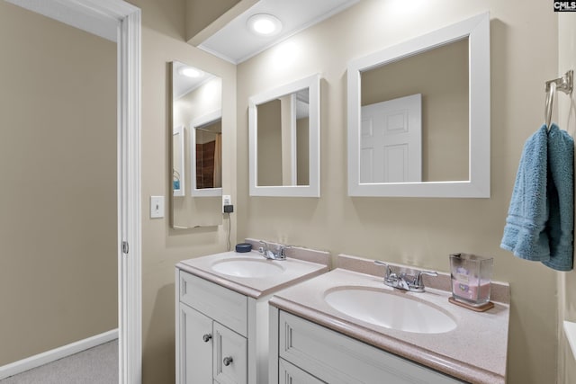 bathroom featuring two vanities, a sink, and baseboards