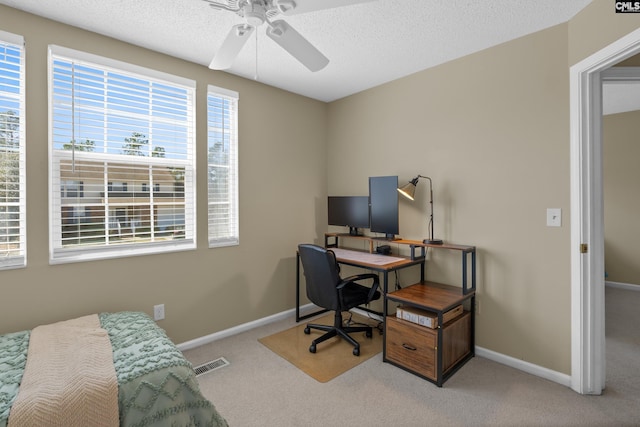 office area with baseboards, a textured ceiling, visible vents, and carpet flooring