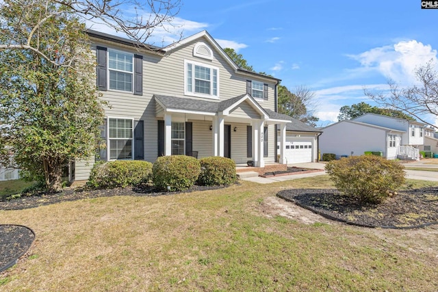 traditional-style home with an attached garage, a front lawn, and concrete driveway