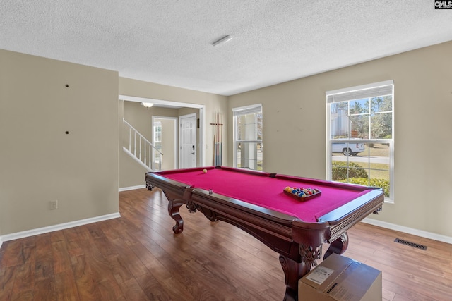 playroom featuring a textured ceiling, wood-type flooring, visible vents, and baseboards