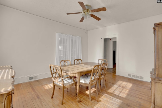 dining area featuring baseboards, light wood finished floors, visible vents, and a ceiling fan