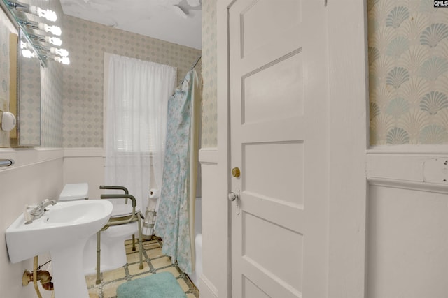 full bath with tile patterned floors, a sink, toilet, and wallpapered walls