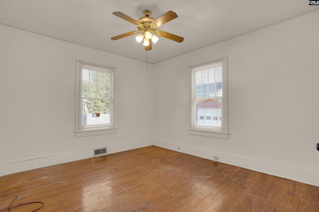 unfurnished room with wood-type flooring, ceiling fan, and a wealth of natural light