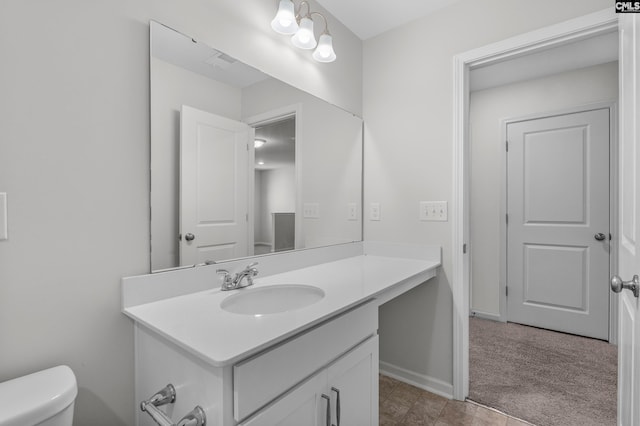 half bathroom with vanity, toilet, and baseboards