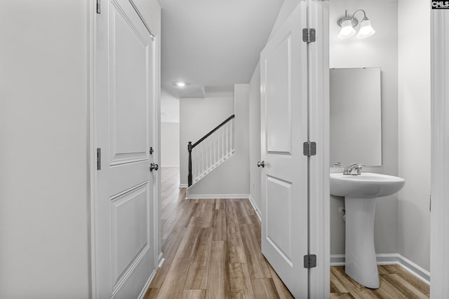 bathroom with a sink, baseboards, and wood finished floors