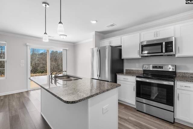 kitchen featuring crown molding, stainless steel appliances, visible vents, a sink, and dark stone counters