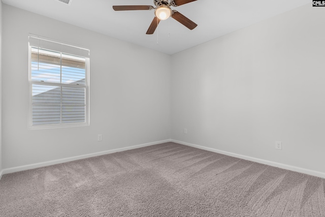 carpeted spare room with ceiling fan and baseboards