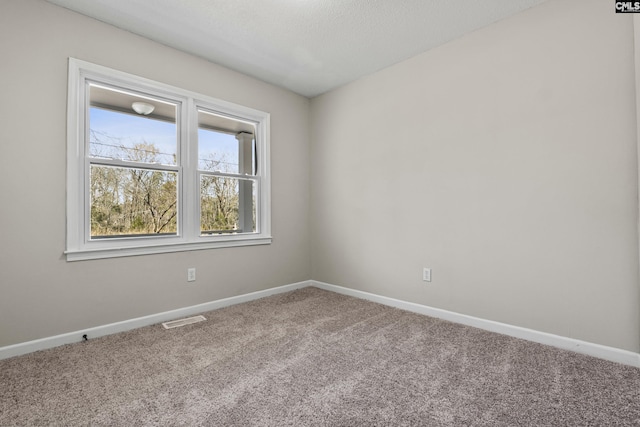 carpeted empty room featuring visible vents and baseboards