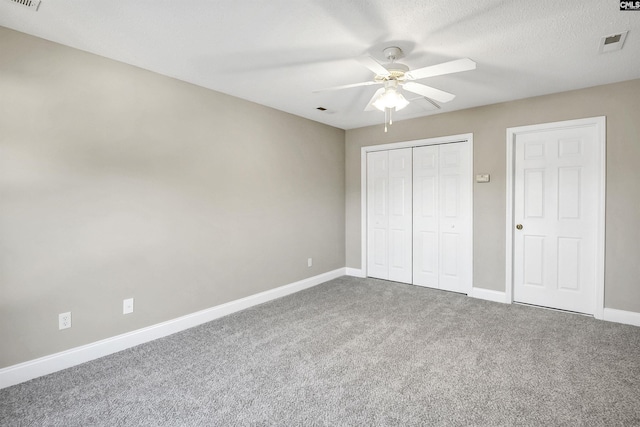 unfurnished bedroom with a closet, carpet flooring, visible vents, and baseboards