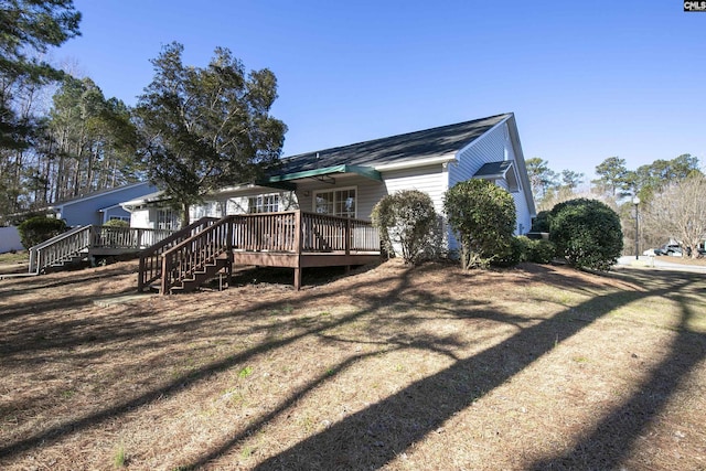 rear view of house with stairs and a deck