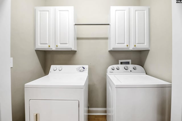 clothes washing area with cabinet space and separate washer and dryer