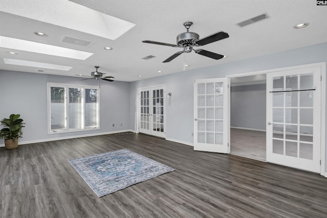 unfurnished living room featuring french doors, a skylight, wood finished floors, and visible vents