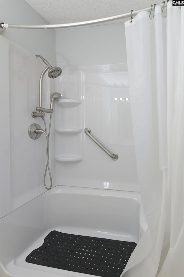 bathroom with a textured ceiling and a shower with curtain