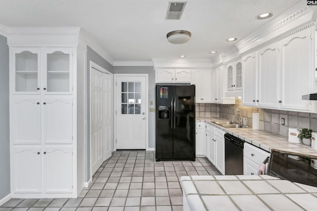 kitchen featuring white cabinetry, a sink, tile countertops, and black appliances