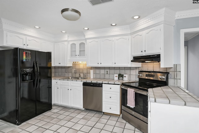 kitchen with tile countertops, stainless steel appliances, visible vents, white cabinets, and under cabinet range hood