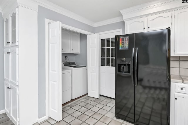 kitchen with black refrigerator with ice dispenser, crown molding, light countertops, white cabinetry, and separate washer and dryer