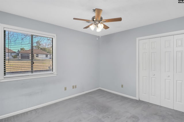 unfurnished bedroom featuring a ceiling fan, carpet, baseboards, and a closet