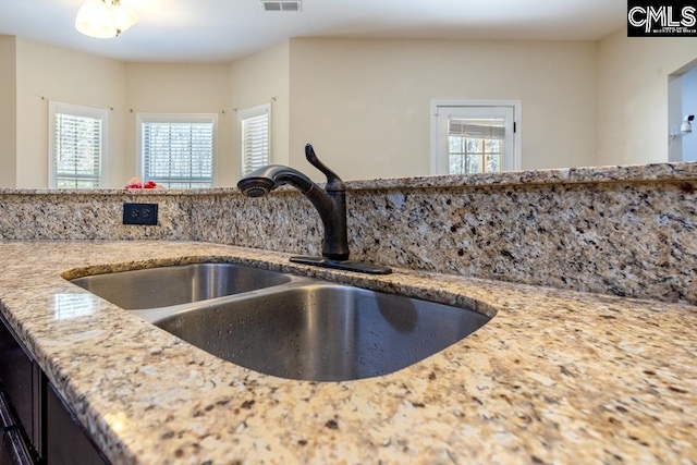 interior details featuring visible vents, light stone counters, and a sink