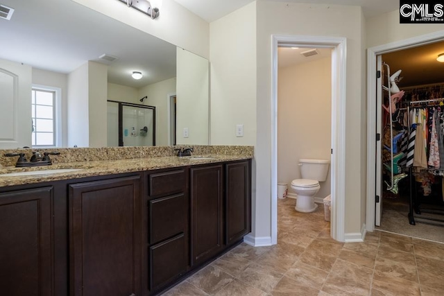 full bath with toilet, a stall shower, a sink, and visible vents