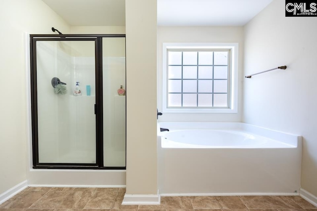 full bath featuring a garden tub and a shower stall