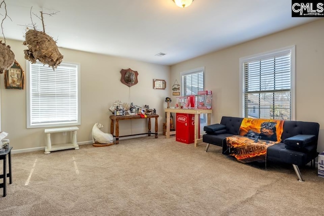 sitting room with carpet floors, baseboards, and visible vents