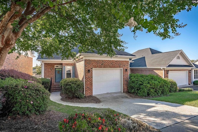 view of front of property featuring an attached garage, driveway, and brick siding