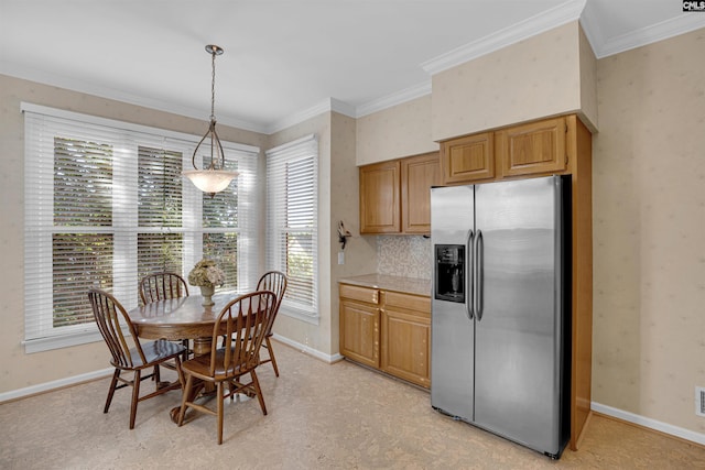 kitchen featuring pendant lighting, crown molding, stainless steel fridge with ice dispenser, light countertops, and baseboards