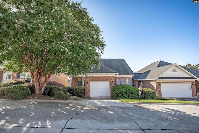 view of front of home featuring driveway, brick siding, and an attached garage