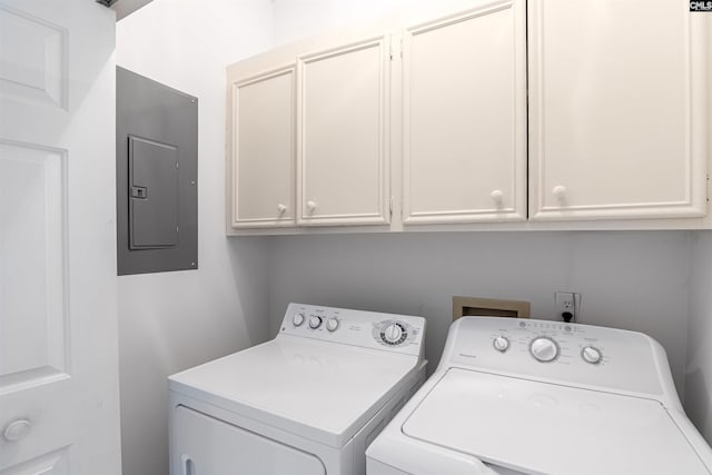 washroom with cabinet space, electric panel, and washing machine and clothes dryer