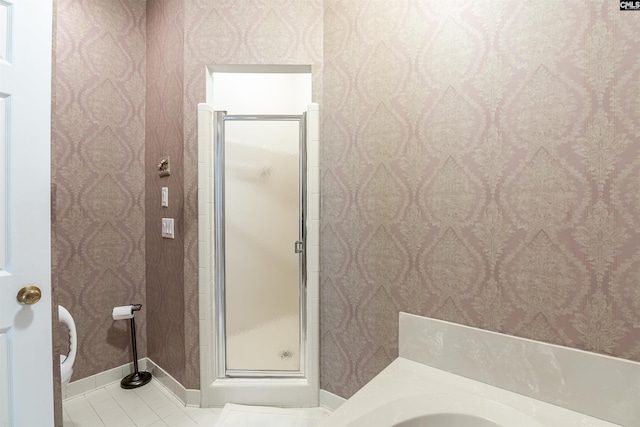 full bath featuring toilet, wallpapered walls, a shower stall, and tile patterned flooring