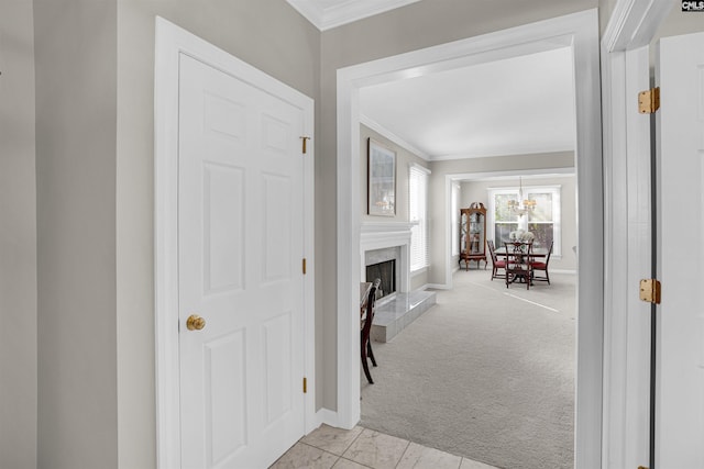 interior space featuring crown molding, baseboards, and light colored carpet