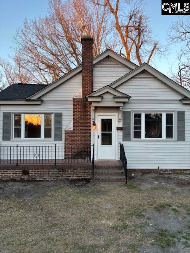 view of front of house featuring a front yard and a chimney