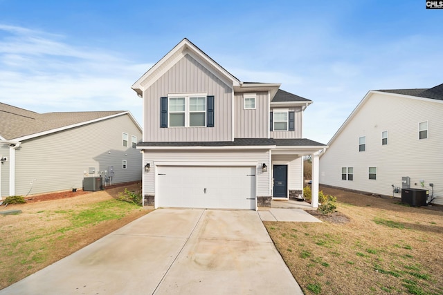 view of front facade with central air condition unit, concrete driveway, board and batten siding, a front yard, and a garage