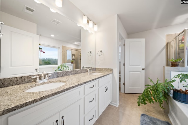 full bathroom featuring visible vents, a sink, a shower stall, and double vanity