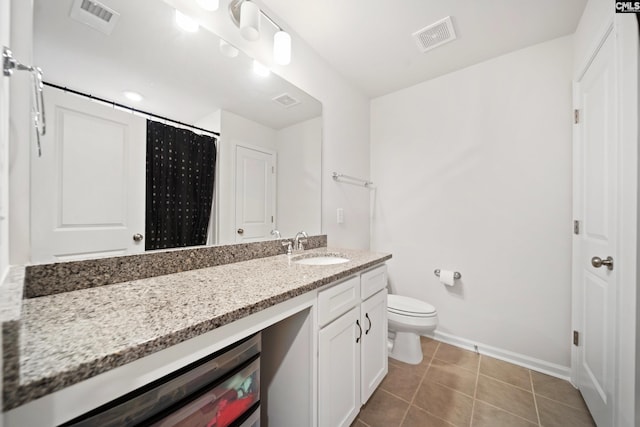 bathroom featuring toilet, vanity, visible vents, and tile patterned floors