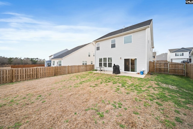 rear view of property featuring a yard, a patio area, and a fenced backyard