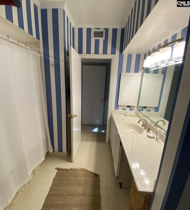 bathroom with visible vents, vanity, and wallpapered walls