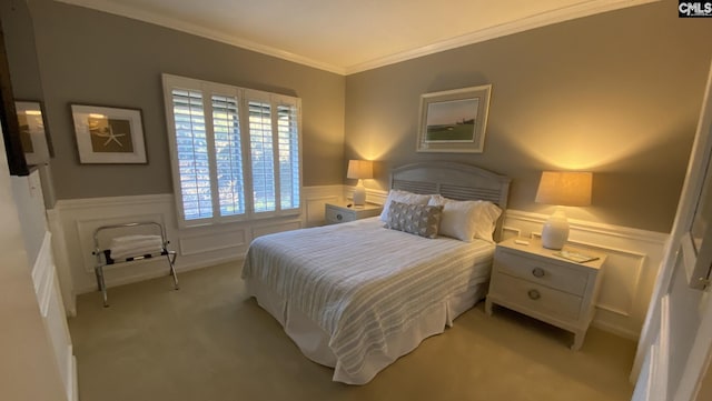 bedroom with light carpet, a wainscoted wall, a decorative wall, and crown molding