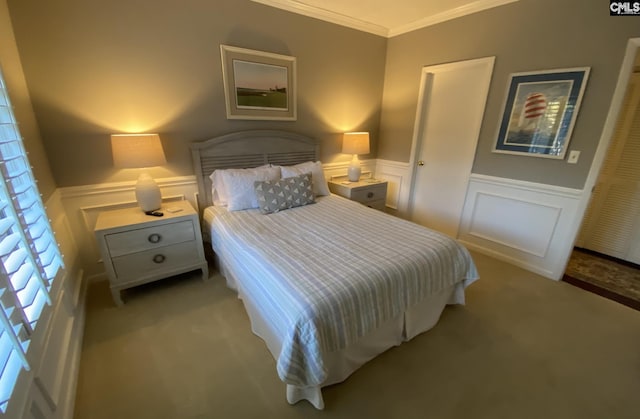 carpeted bedroom featuring ornamental molding and wainscoting