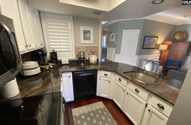 kitchen with dishwasher, electric range oven, dark wood-type flooring, white cabinetry, and a sink