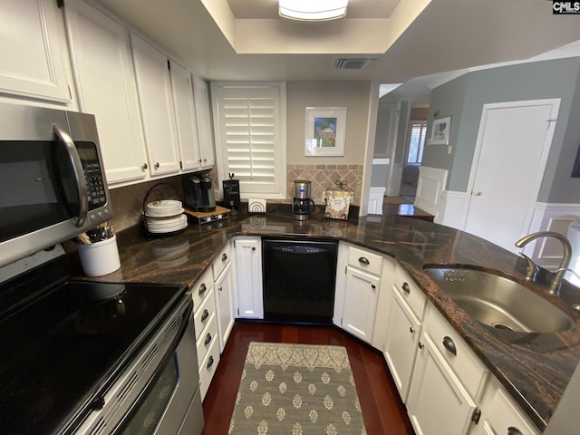 kitchen with black dishwasher, visible vents, a raised ceiling, stainless steel microwave, and a sink