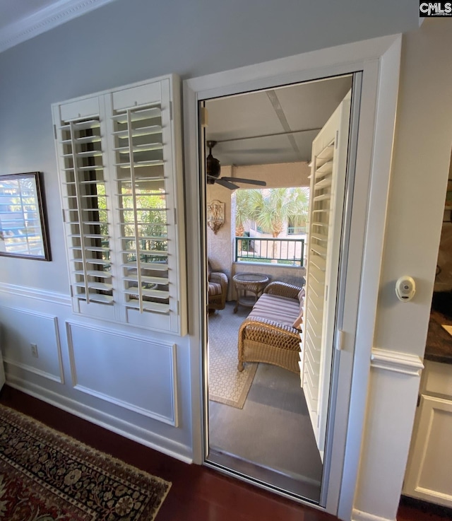 doorway with wainscoting and a ceiling fan