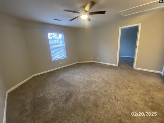 carpeted spare room featuring visible vents, ceiling fan, and baseboards